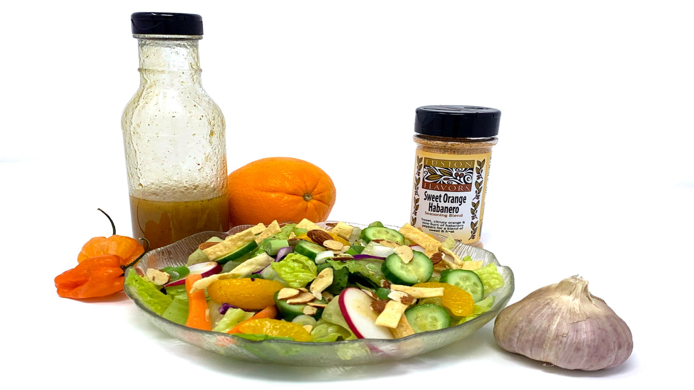Salad with Sweet Orange Habanero dressing and greens, almonds, wonton strips, mandarin oranges for a fresh sweet heat salad.