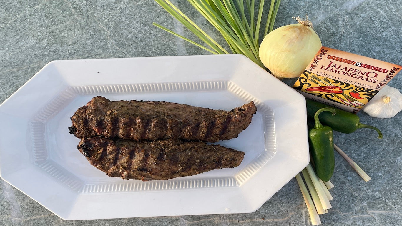 Pork tenderloin grilled and placed on a white platter with Jalapeno Lemongrass Fusion Flavors seasoning blend