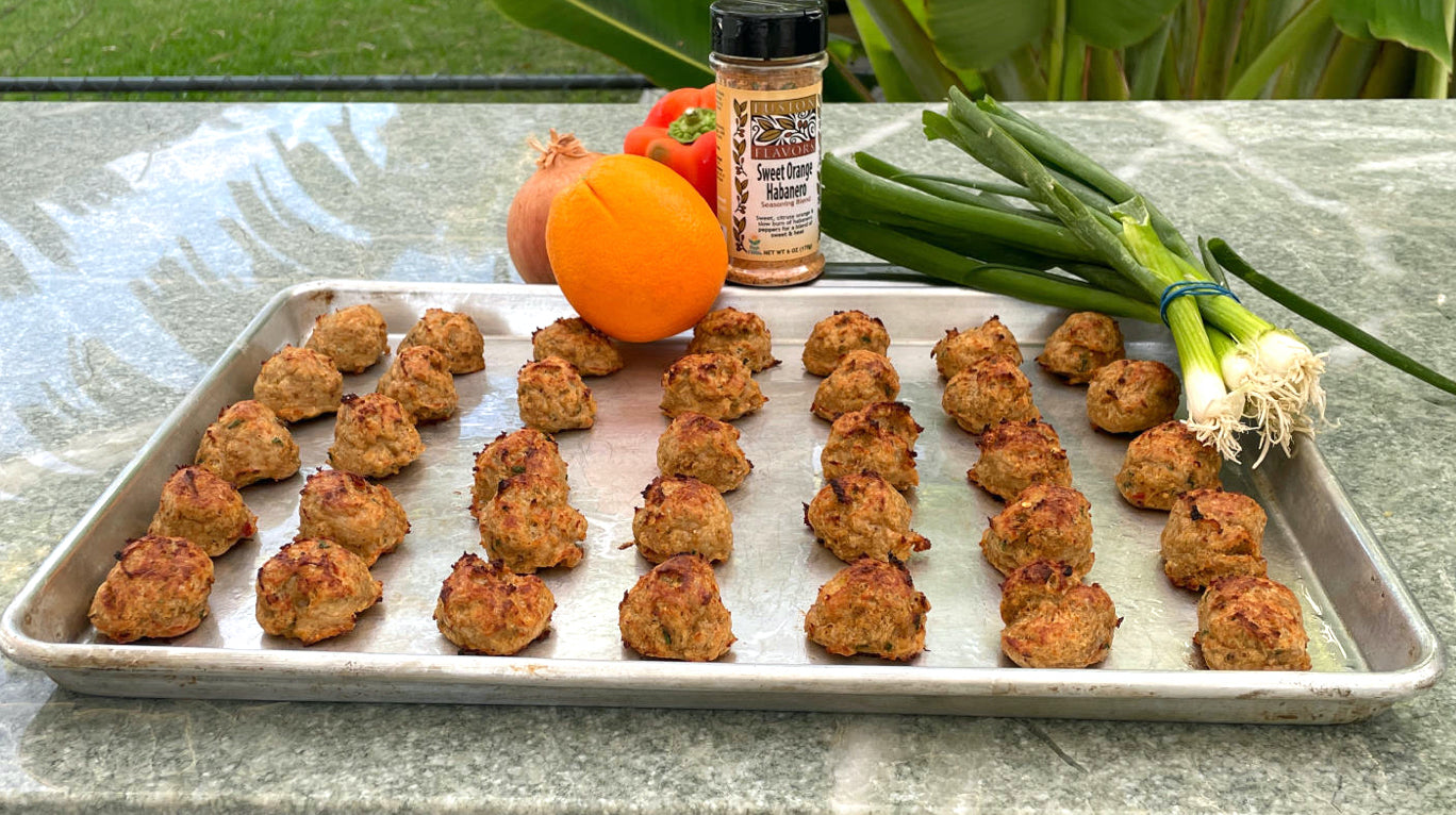Sheet pan with baked meatballs , pictured with Sweet Orange Habanero seasoning