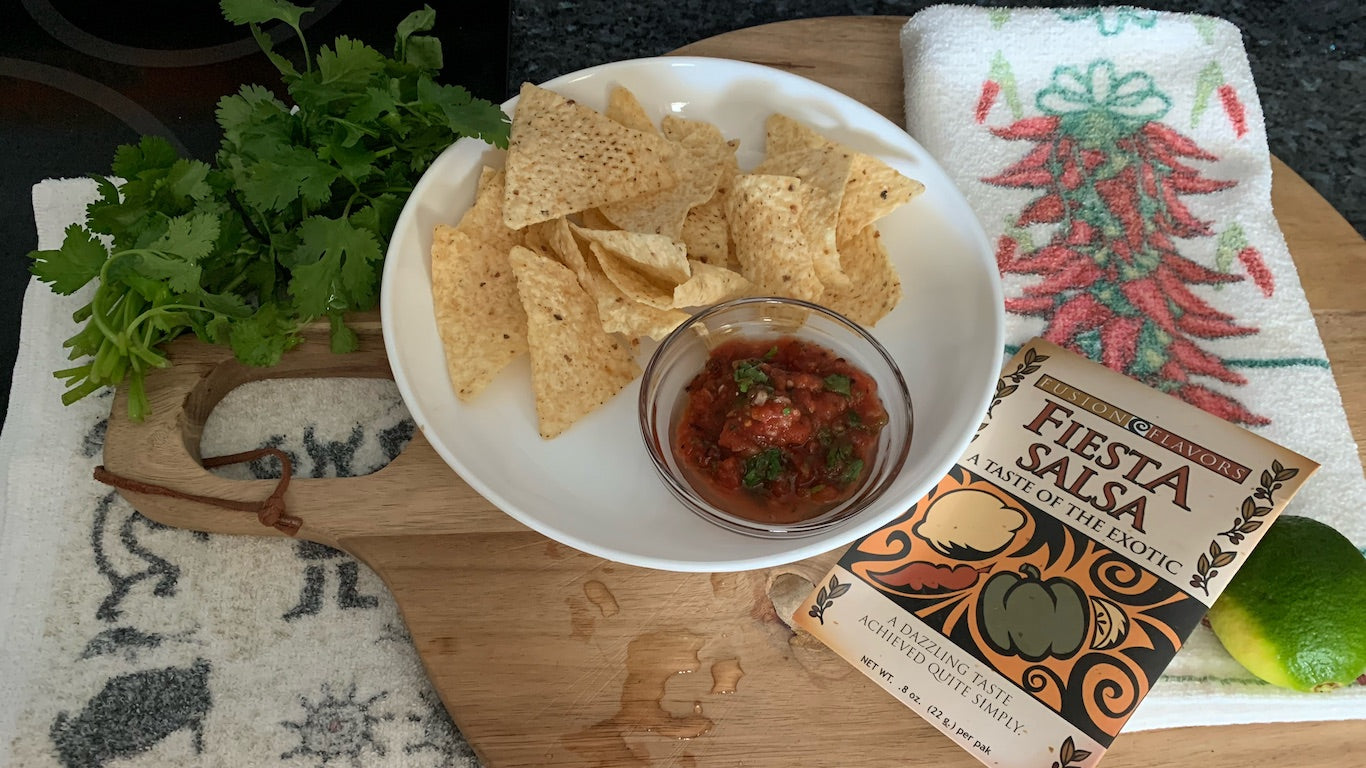 Picture of Tortilla chips and salsa garnished with lime and cilantro